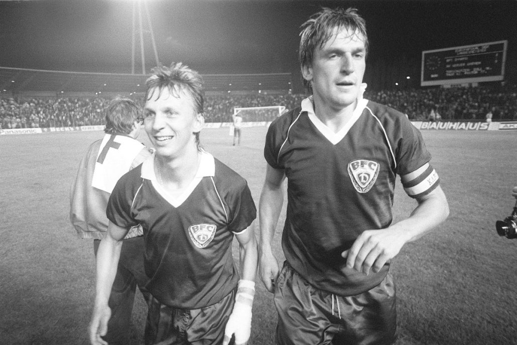 Andreas Thom e o capitão Frank Rohde após vitória por 3 a 0 no jogo de ida contra o Werder Bremen na primeira fase da Copa dos Campeões de 1988/89. O Bremen venceria por 5 a 0 o jogo de volta na Alemanha Ocidental (Foto: Roland Holschneider/DPA)